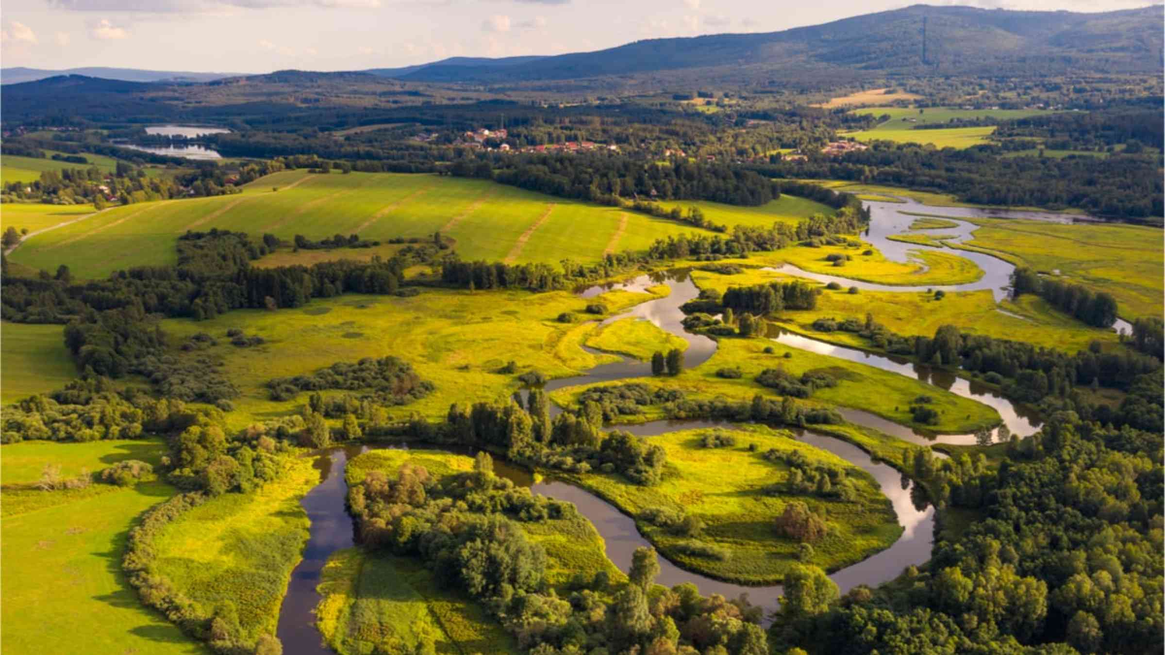 River flowing through green fields and hills.