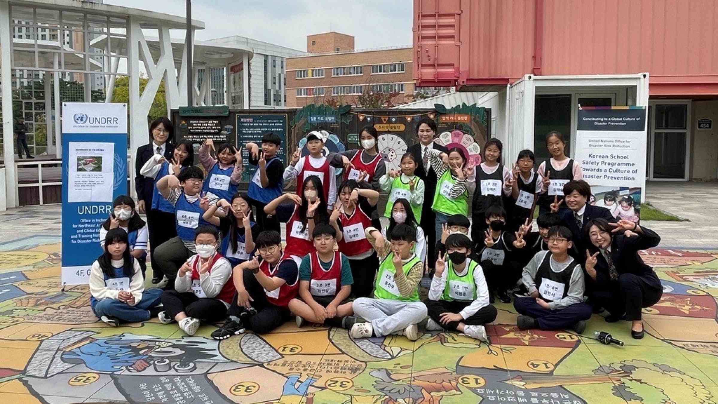 Group photo of children at the a life-size Riskland game in Hwangseong Republic of Korea